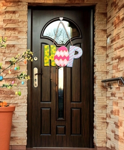 Easter HOP wooden door sign with floral egg pattern hanging on a rustic wood door
