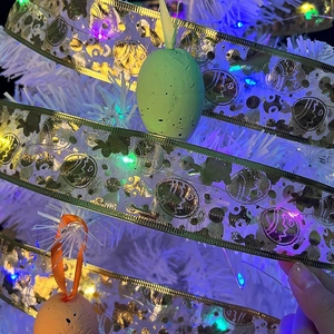 Detail of Easter ribbon with gold prints and speckled macaron egg ornaments on LED tree