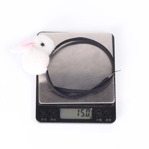 Detail showing the lightweight 15.0g plush bunny ear headband on a digital scale