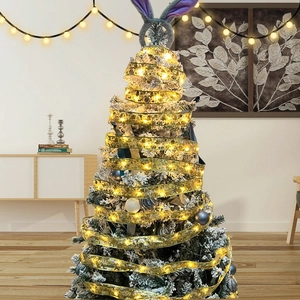 Detail of warm white LED ribbon lights on a Christmas tree with golden sequins and rabbit ears