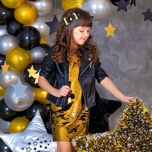 Kid party bow hair clip in black and gold mesh style worn by a girl at a festive event