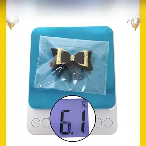 Detail of a black and gold sequin bow hair clip with star mesh in its clear packaging