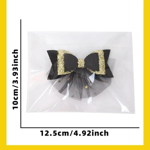 Detail view of black and gold bow hair clip with star mesh and 12.5cm size markings
