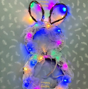 Detail of Easter bunny wreath with colorful LED lights, white mesh, and silver ribbon bow