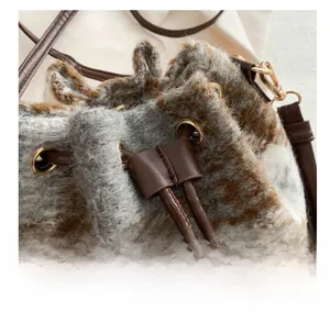 Detail of checkered plush bucket bag with leather drawstring and gold metal ring hardware