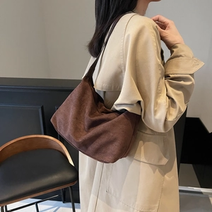 Vintage coffee suede hobo bag shown as a shoulder bag on a model in a modern interior