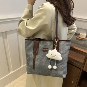 Retro grey tote bag with brown leather handles and cute plush cloud charm for office use