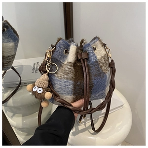 Detail of plush plaid bucket bag featuring blue brown check pattern and drawstring