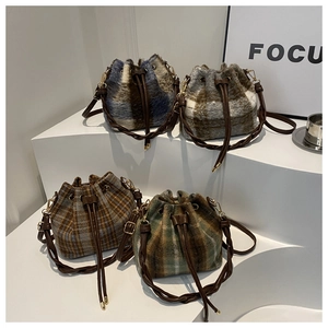 Detail showing four textured drawstring bucket bags on minimalist geometric stairs