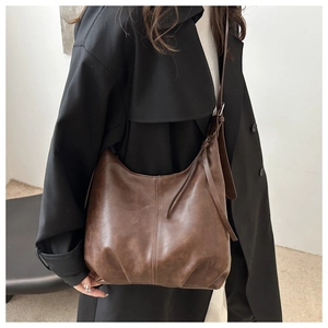 Detail einer dunkelbraunen Vintage-Hobo-Tasche aus Kunstleder mit verstellbarem Gurt