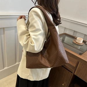 Borsa a spalla hobo in pelle intrecciata marrone di grande capacità in un contesto di stile