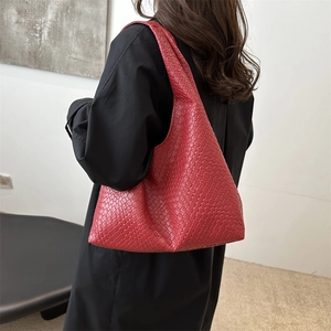 Borsa tote hobo rossa intrecciata minimalista da donna vista da una prospettiva laterale