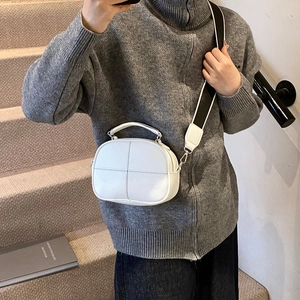White faux leather crossbody pillow bag with textured finish and sporty canvas strap