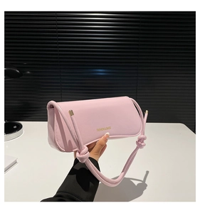 Detalle del bolso de hombro rosa claro con correa anudada y herrajes dorados