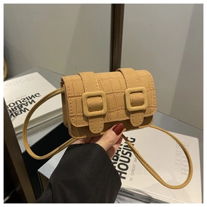 Detailopname van camel mini-tas met krokodillenprint en decoratieve dubbele gesp-details