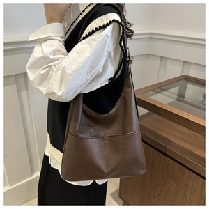 Close-up of a vintage brown leather Hobo shoulder bag with twin pockets and retro texture
