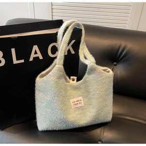 Close-up of knit tote bag with colorful macaron blend texture and logo label on leather