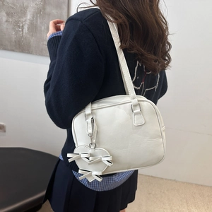 Bolso de hombro blanco minimalista con colgante de corazón mostrado por modelo real