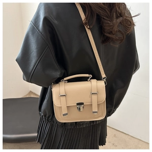 Vista posteriore di una modella con una borsa a tracolla retrò beige e fibbie