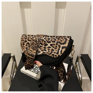 Close-up of leopard print saddle bag with gold buckle and wide shoulder strap
