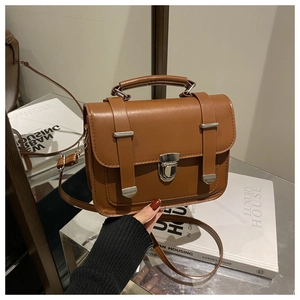Dettaglio della borsa a tracolla vintage marrone con manico e chiusura a fibbia in metallo