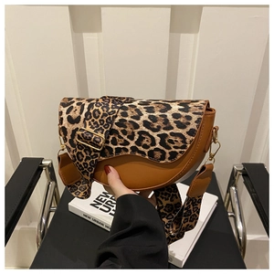 Detail of trendy leopard print saddle bag with brown leather and wide shoulder strap