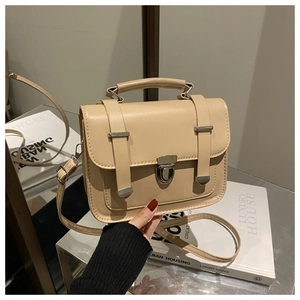 Dettaglio della borsa vintage beige con fibbia metallica e superficie in pelle PU