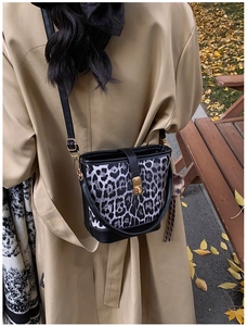 Outdoor-Ansicht der Leoparden-Beuteltasche mit schwarzem Leder und Herbstlaub