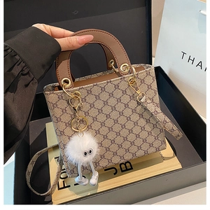 Detail of vintage patterned tote bag with plush charm inside a premium gift box