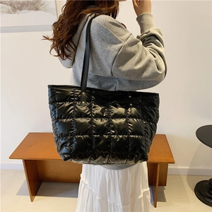 Minimalist black quilted nylon tote bag with leather straps for daily commute