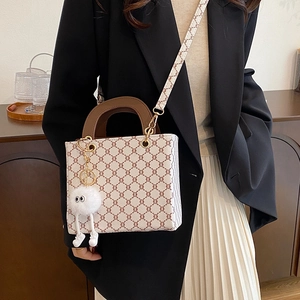 Stylish white tote bag with brown geometric pattern and white fur pompom charm