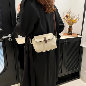 Retro cream white square crossbody bag in lychee leather worn with a black coat