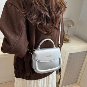 Sac selle croissant argenté chic avec poignée supérieure et lettrage logo mode élégant