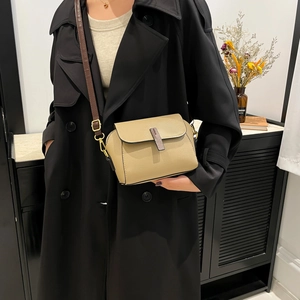 Chic beige textured leather crossbody square bag with brown strap on model