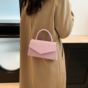 Pink sequin crossbody bag with gold chain and top handle shown on a model