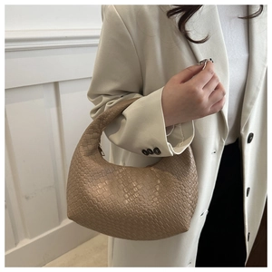 Detailed close-up of beige woven leather texture on a hobo shoulder bag for women
