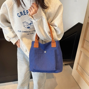 Contrast canvas tote bag in navy blue with orange handles and front metal buckle pocket