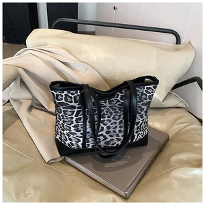 Detail of black and white leopard print tote bag with leather straps and reinforced bottom