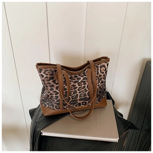Detail view of leopard print tote bag with brown leather edges and reinforced bottom