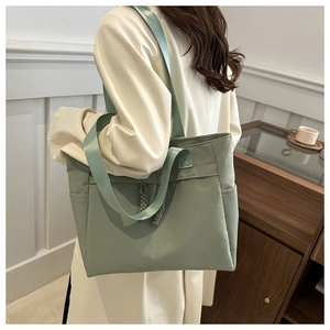 Detail view of mint green lightweight tote bag with stylish braided cord accent and side pocket
