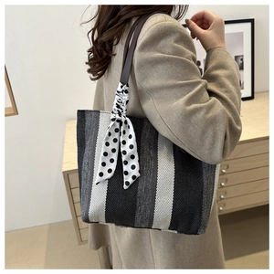 Detail of striped canvas tote bag with polka dot scarf handle decoration