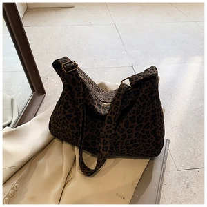 Détails du sac cabas léopard avec boucle en cuivre vintage sur un blazer élégant