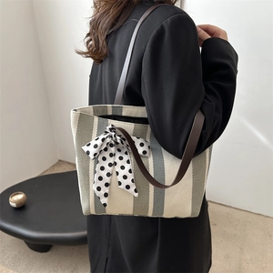 Chic striped canvas tote bag with a polka dot silk scarf and brown leather shoulder straps