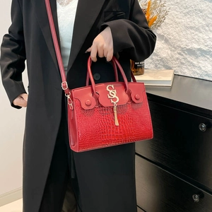 Chic red crocodile texture handbag with gold metal fringe charm and adjustable strap