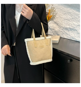 Dettaglio borsa a secchiello in camoscio beige con bordo in shearling sintetico bianco