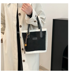 Dettaglio borsa tote nera con bordi in pelliccia sintetica e targhetta fashion chic