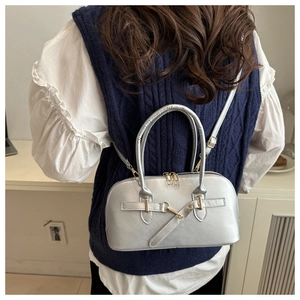 Silver crescent shoulder bag with metallic texture and crossbody strap on model