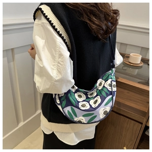 Détail d'un sac demi-lune floral avec bandoulière réglable porté par un mannequin