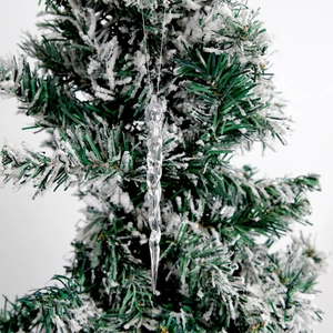 Transparent acrylic icicle ornament with spiral design hanging on a snowy Christmas tree branch
