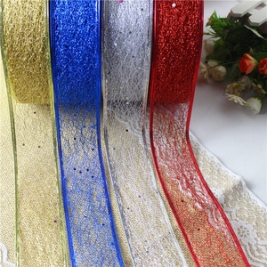 Gros plan de rubans en maille pailletée or, bleu, argent et rouge pour sapin de Noël